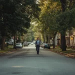Man walking down a quiet tree-lined street in AnthonyLangone Martinsburg WV neighborhood during golden hour